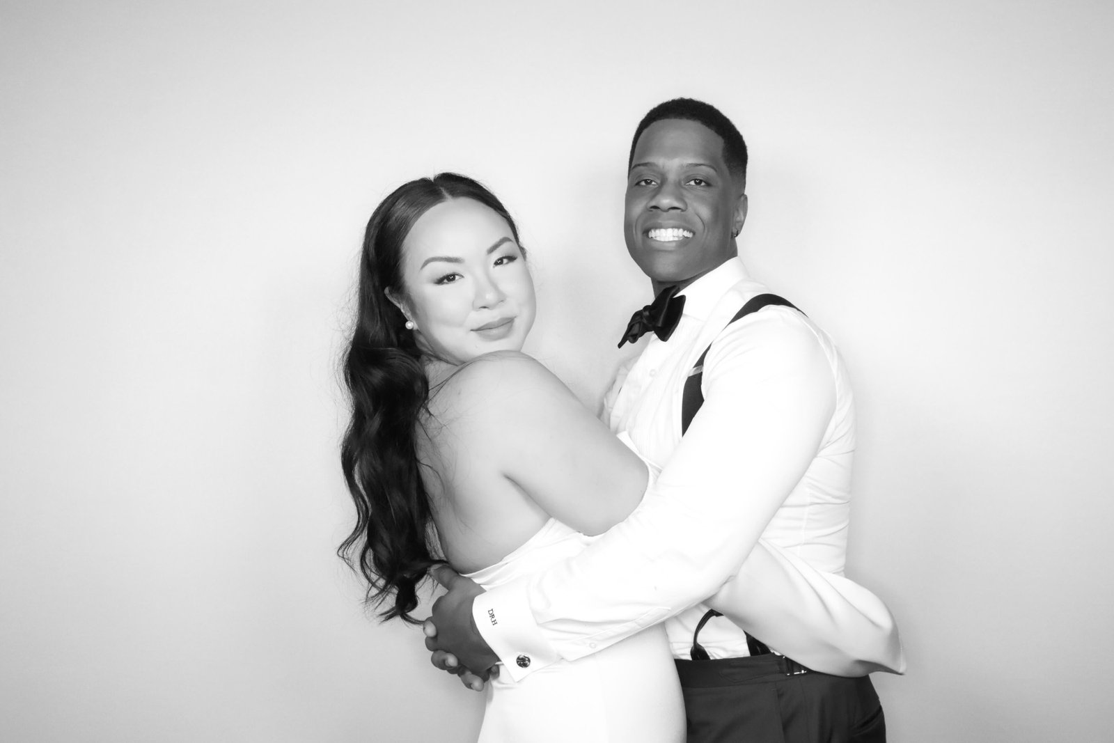 Elegant black and white photo of a couple at their wedding in a glam booth
